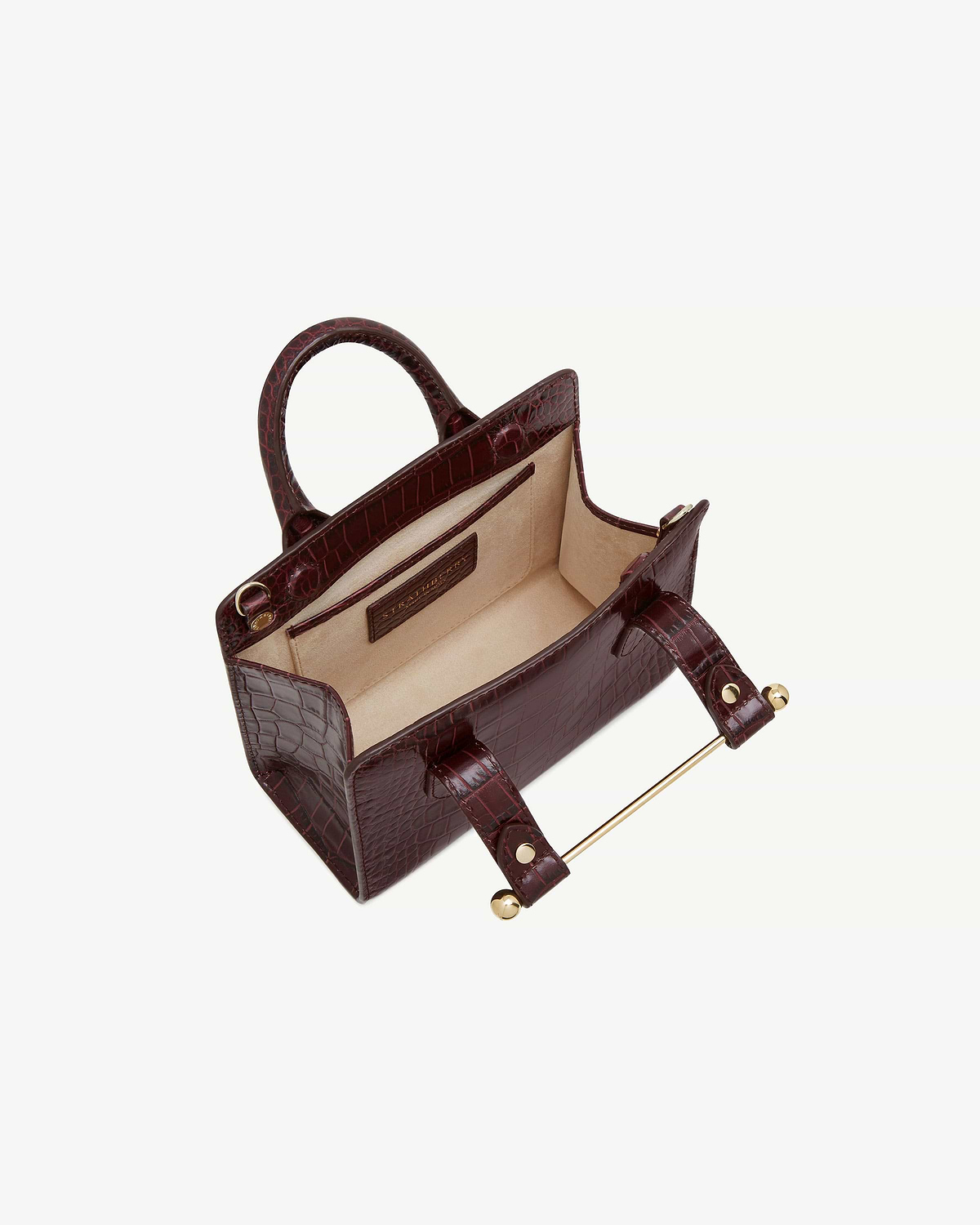 Croc-embossed nano tote with top handles and beige lining, open interior.