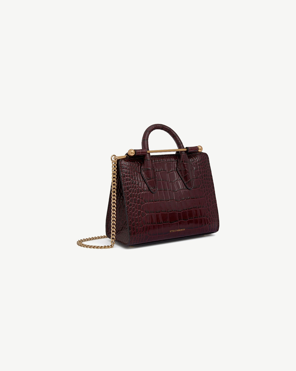 Burgundy croc-embossed nano tote with top handle, gold bar, chain strap, Strathberry.