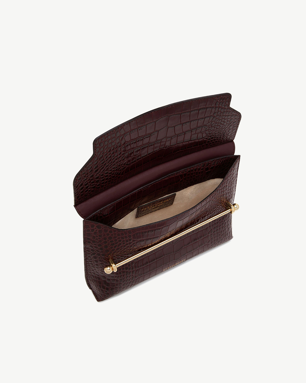 Open burgundy croc-embossed leather bag with gold bar detail and beige interior
