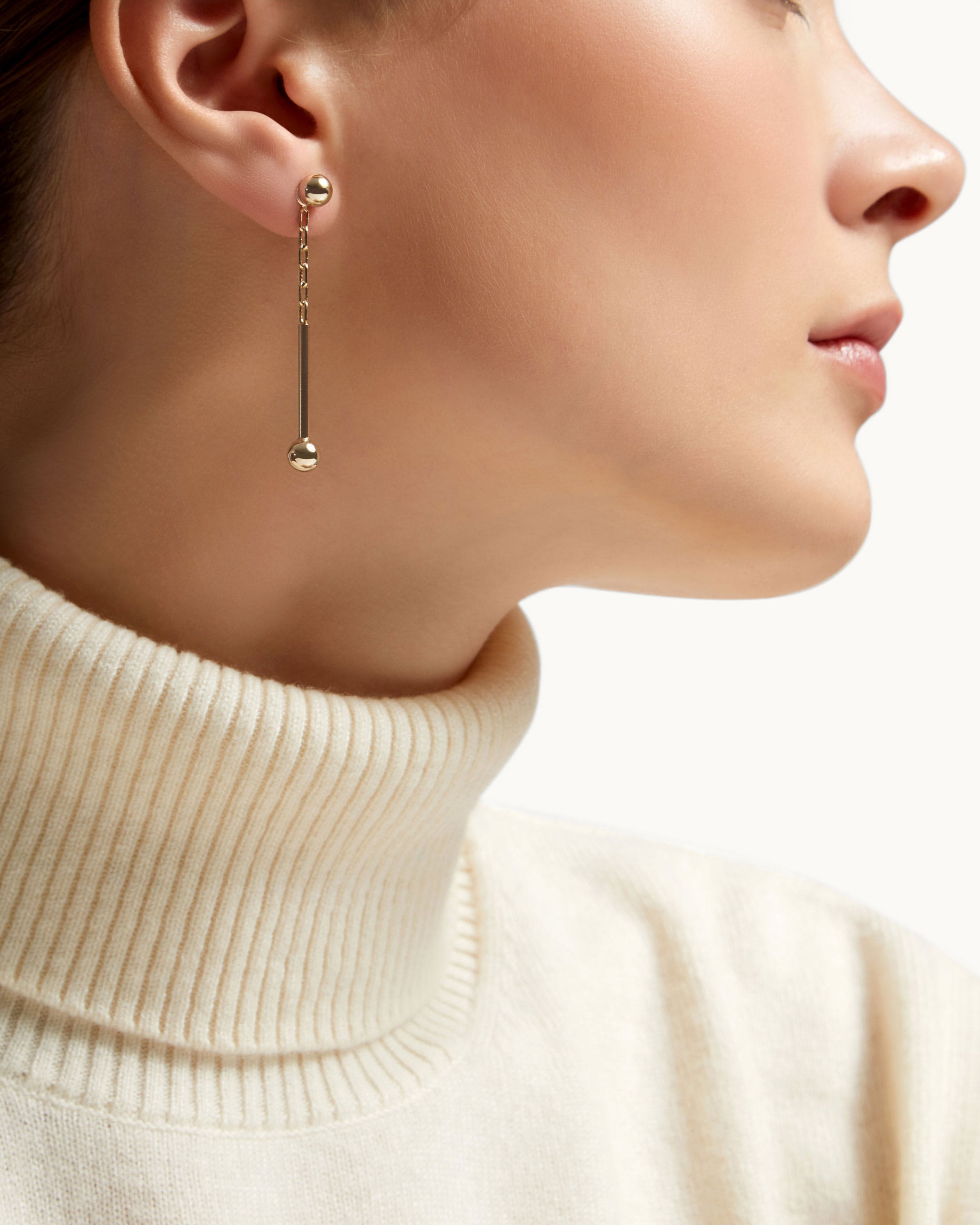 Profile of a woman wearing a 22 carat gold music bar drop earring