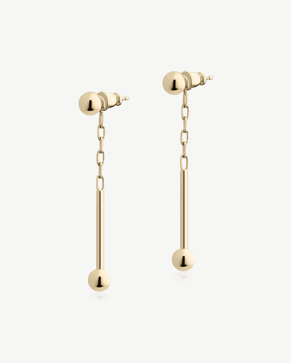 Pair of 22-carat gold gilded music bar drop earrings on white background.