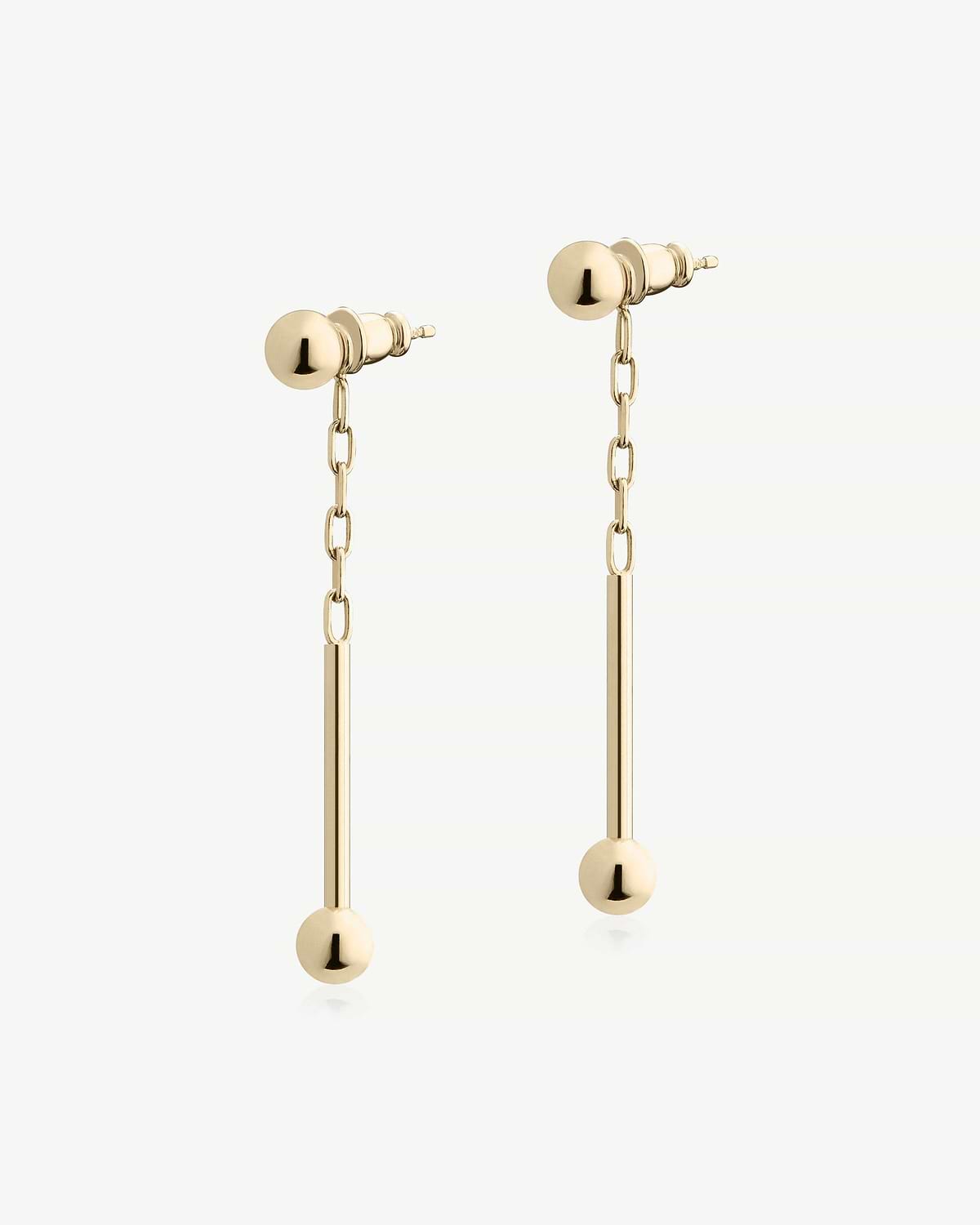 Pair of 22-carat gold gilded music bar drop earrings on white background.
