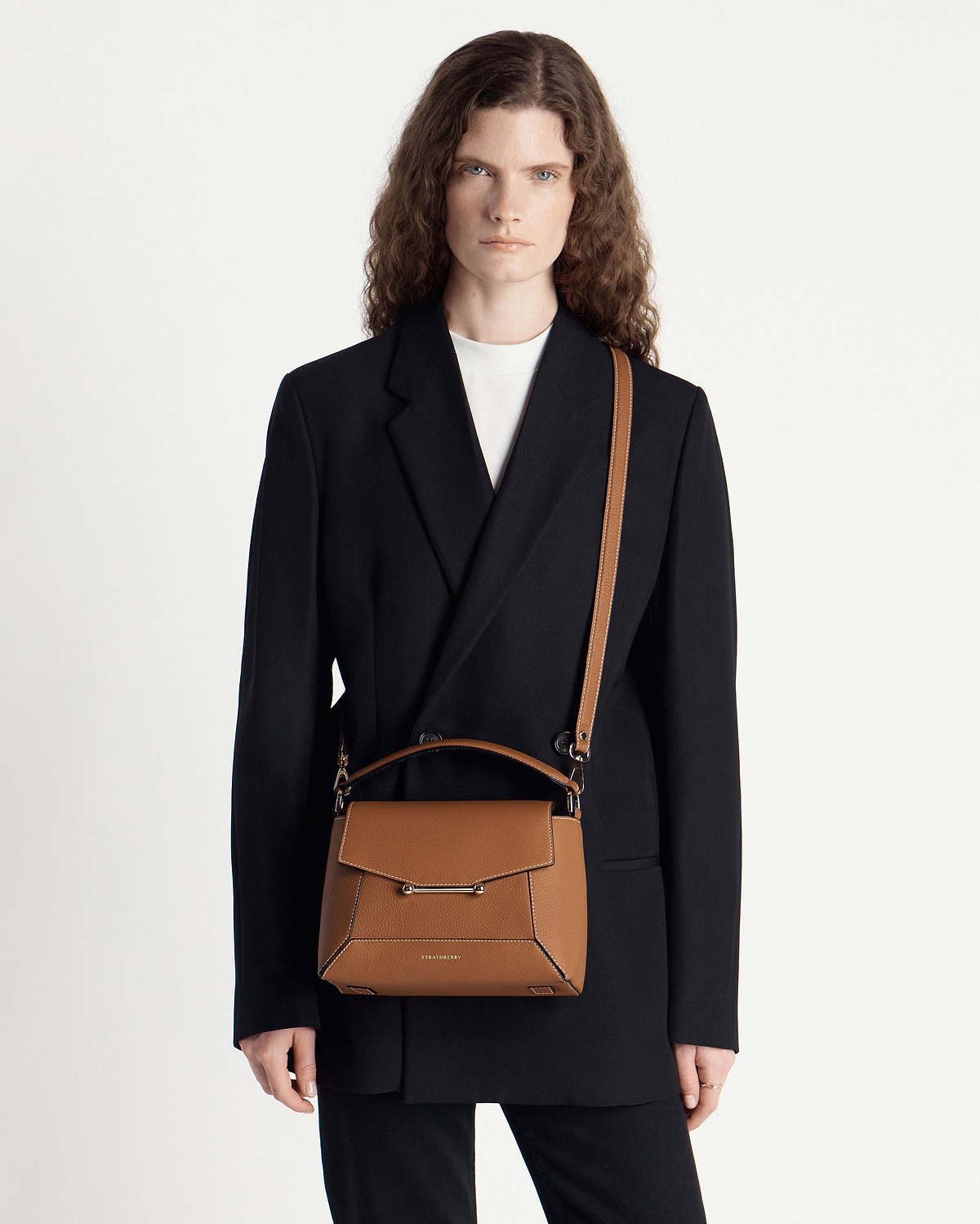 Model wearing Strathberry Mosaic bag in tan with vanilla stitching, front view.
