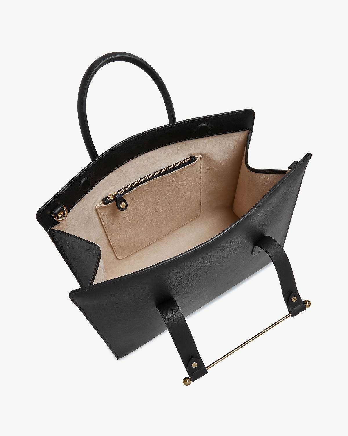 Black leather tote open to show beige suede interior, zip pocket and gold bar.