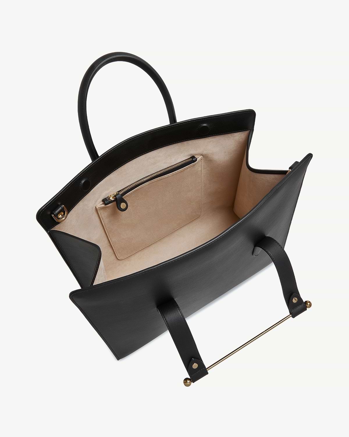 Black leather tote open to show beige suede interior, zip pocket and gold bar.