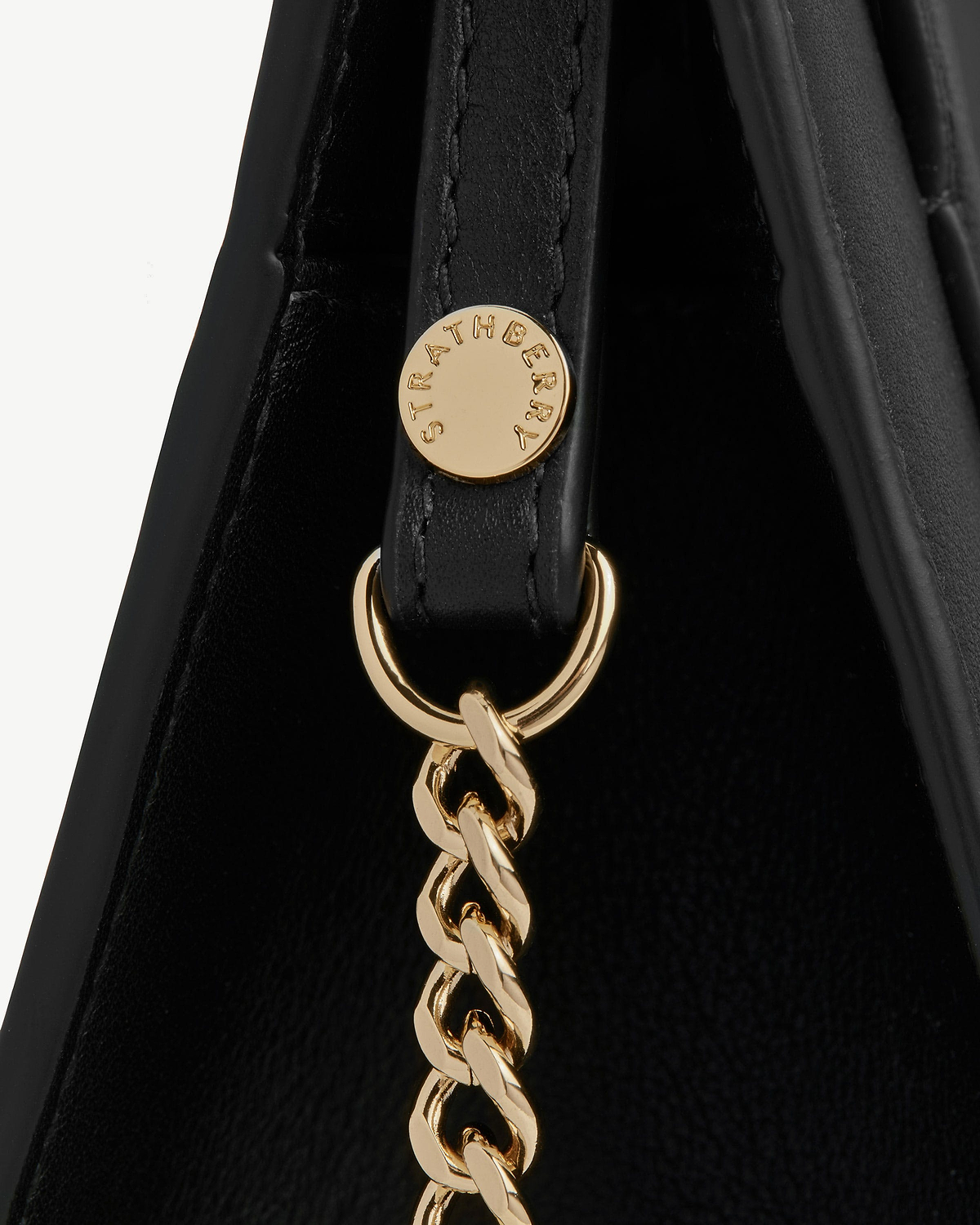 Black leather mini tote strap with gold Strathberry hardware and chain.