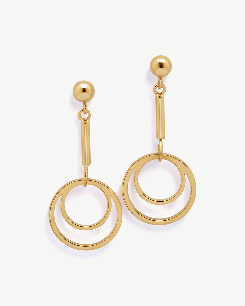 Pair of 22-carat gold gilded circle drop earrings with concentric rings on white background