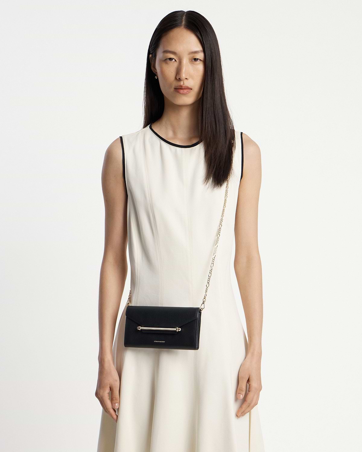 Model wearing black Multrees chain wallet with gold bar and chain strap