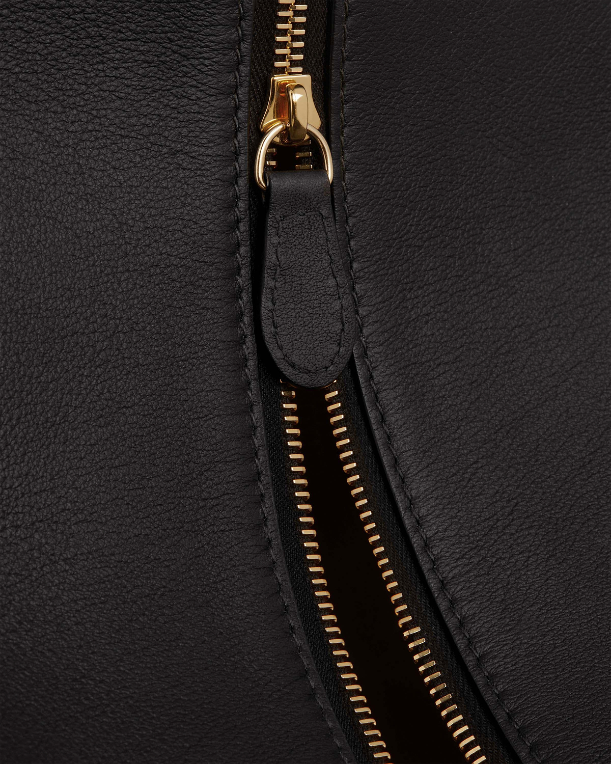 Black pebbled leather crescent bag zip with gold hardware and leather pull tab