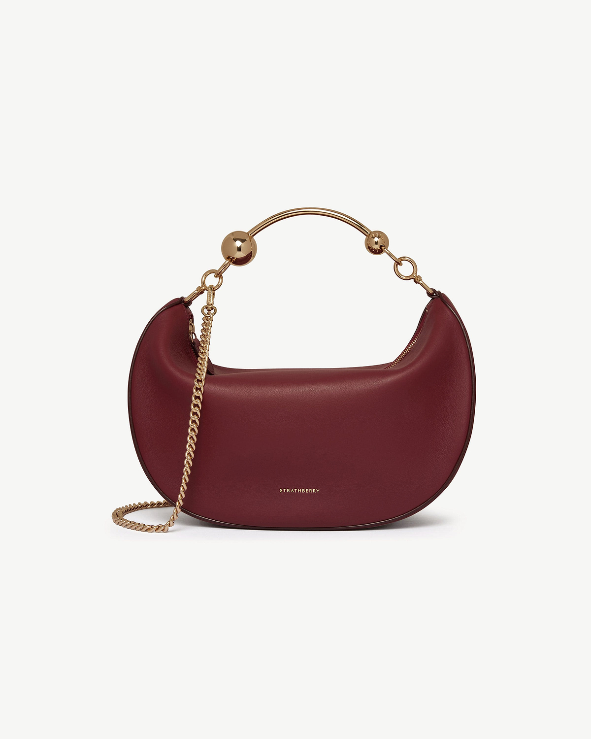 Oxblood crescent moon bag with gold chain, curved metal handle and Strathberry logo