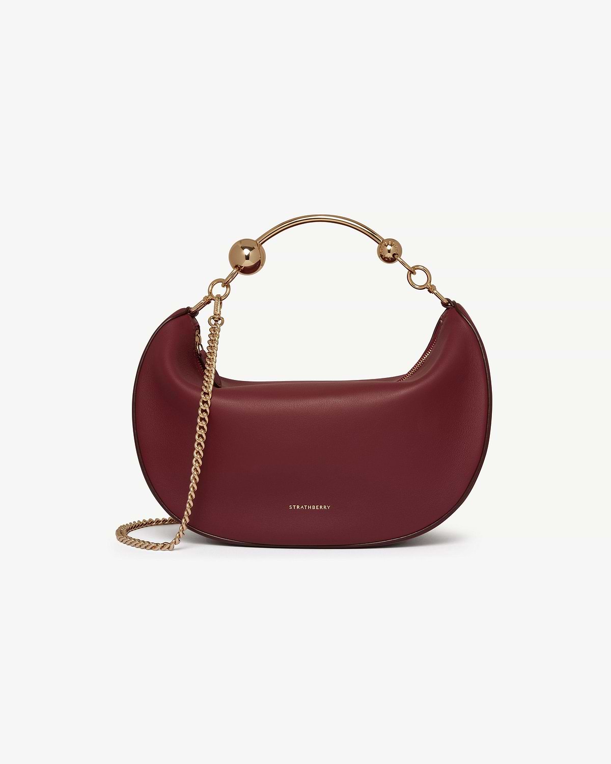 Oxblood crescent moon bag with gold chain, curved metal handle and Strathberry logo