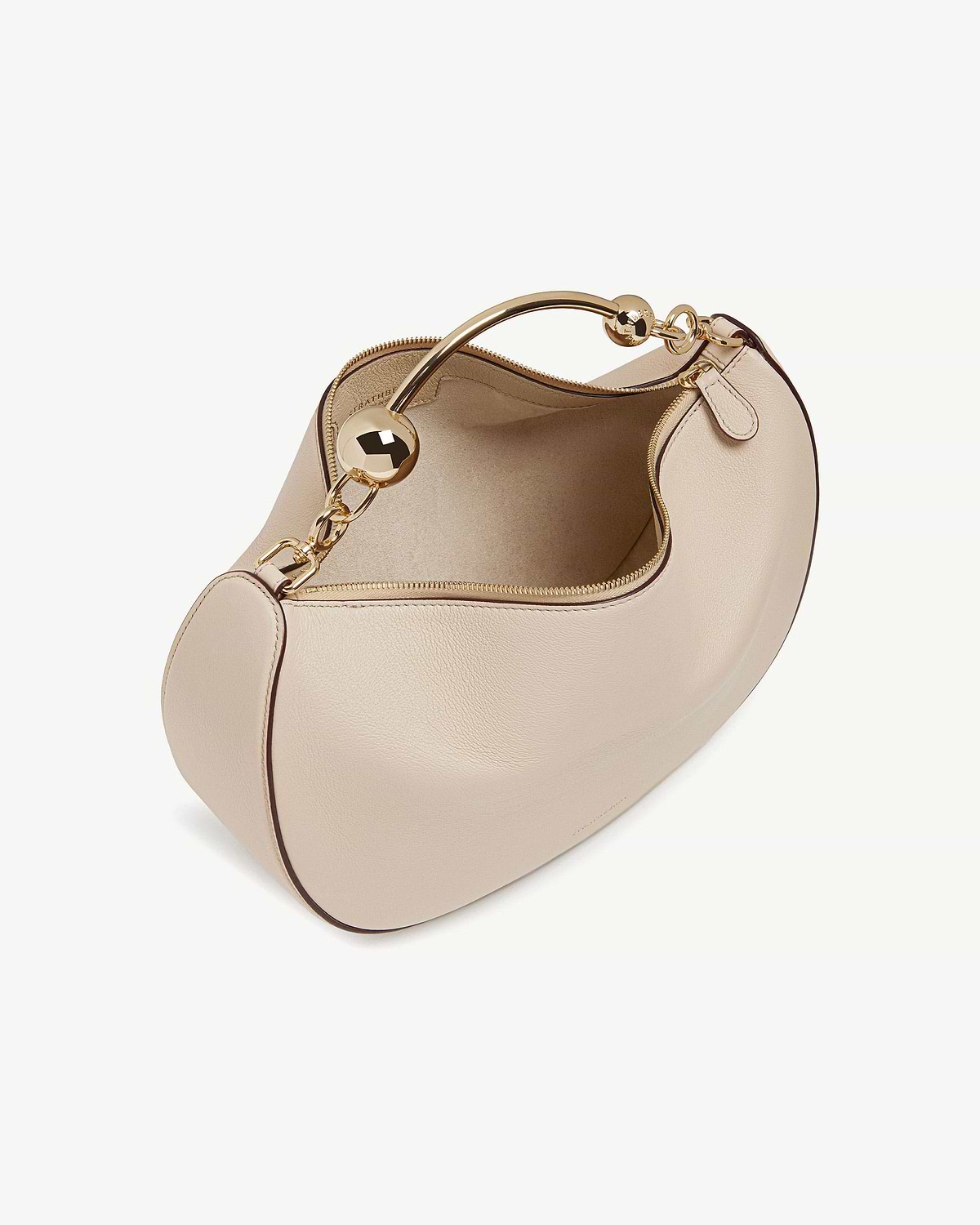 Oat crescent moon leather bag with gold curved handle and zip.