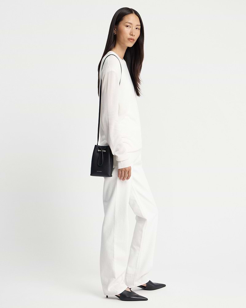 Model wearing black Strathberry Osette midi pouch with thin shoulder strap