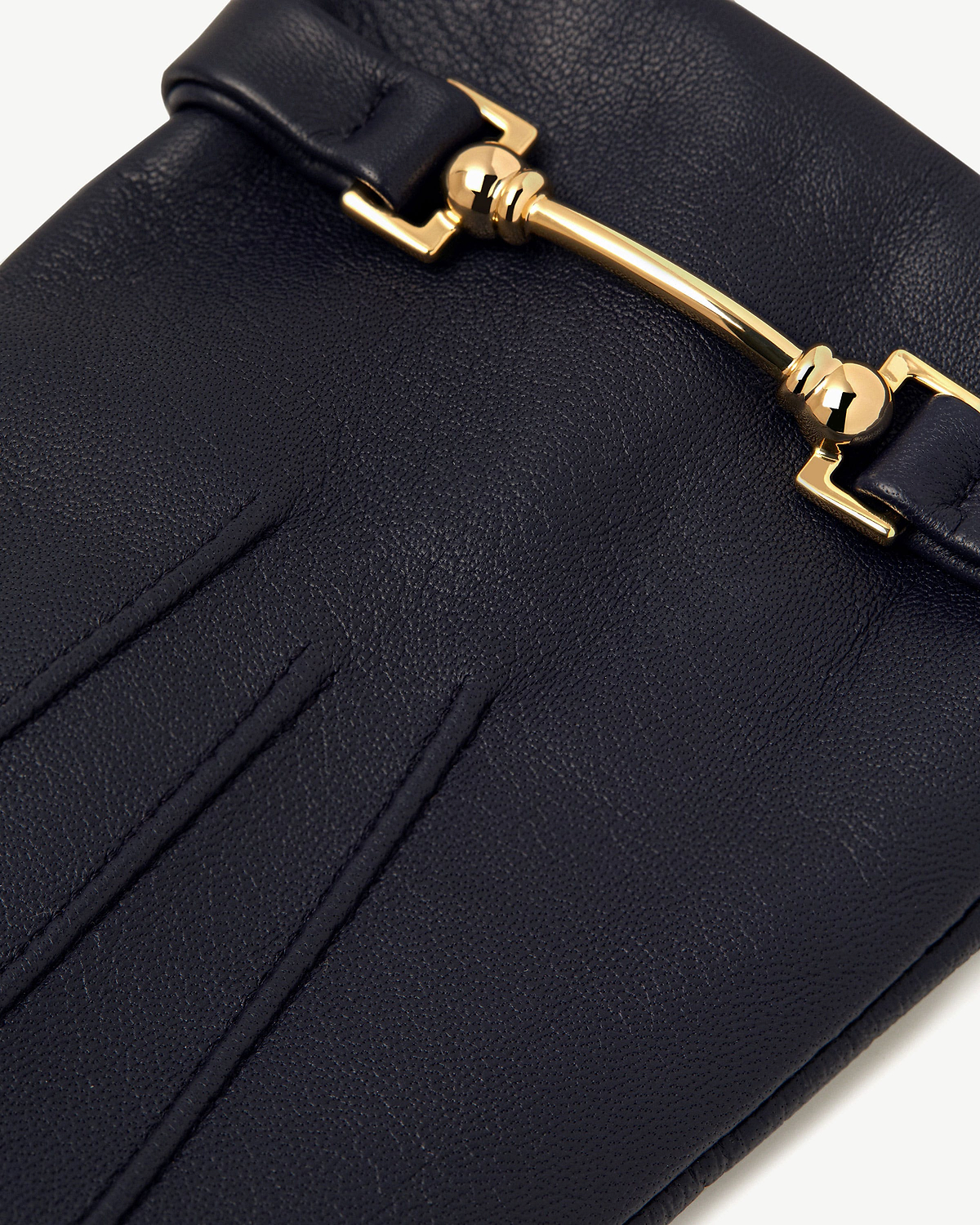 Navy leather glove showing gold metal bar detail and stitched seams