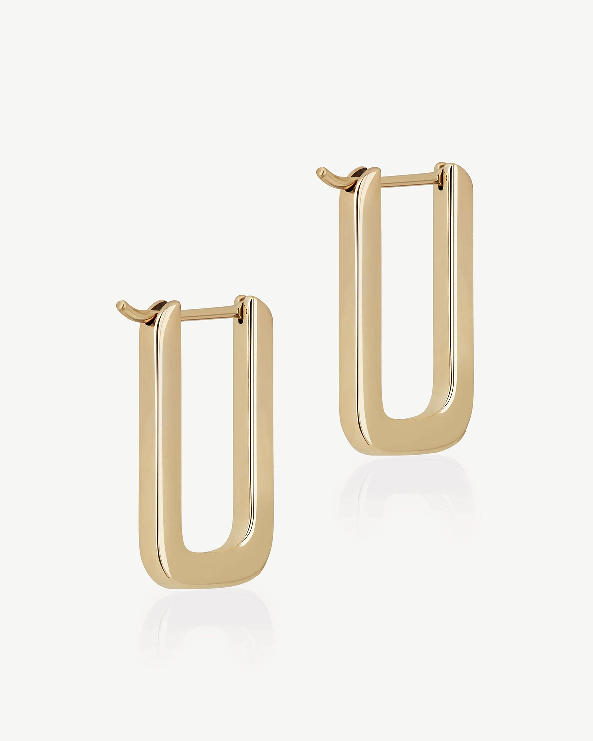 Pair of 22 carat gold gilded rectangular hoop earrings on white background