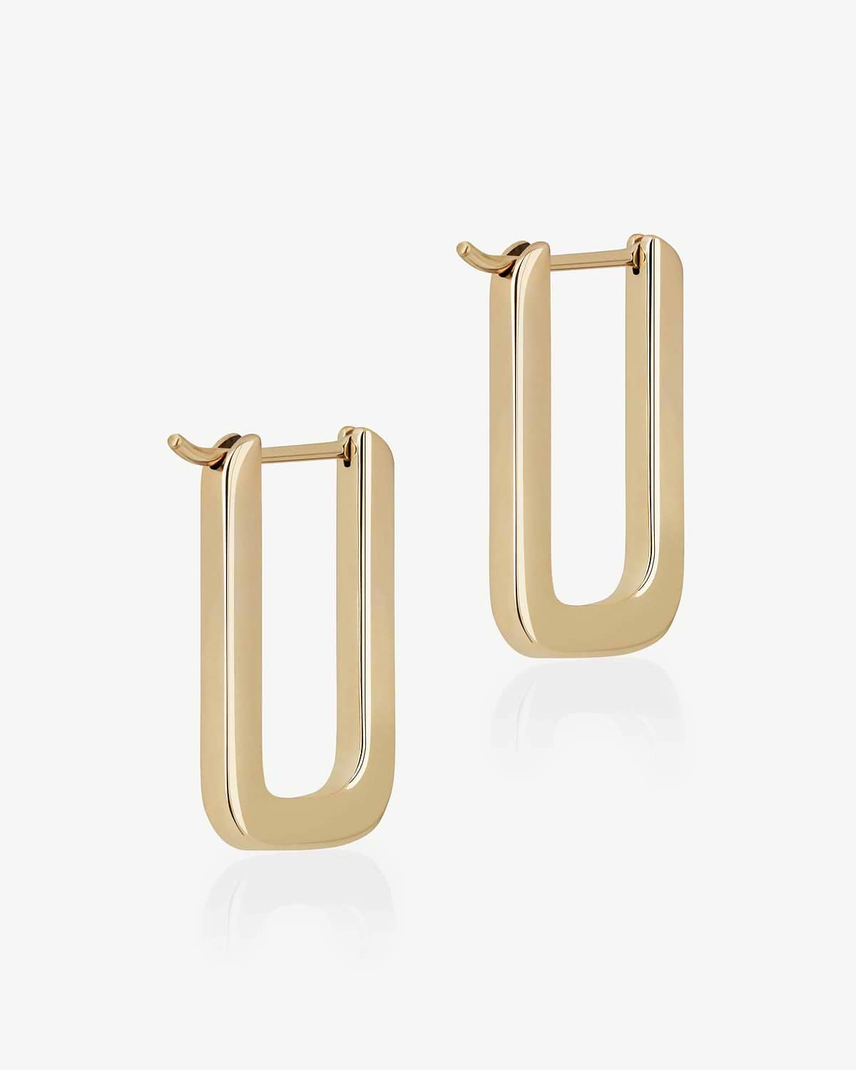Pair of 22 carat gold gilded rectangular hoop earrings on white background