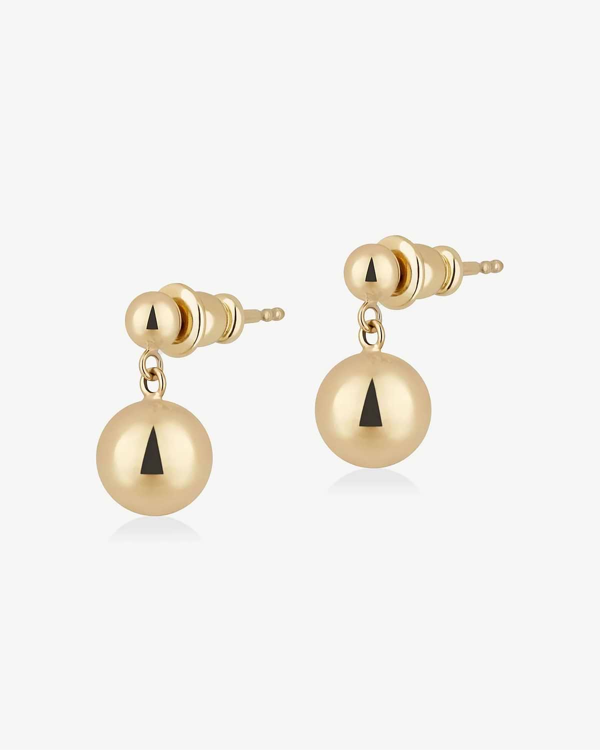 Pair of gold drop stud earrings with black triangular inlay on spherical drops
