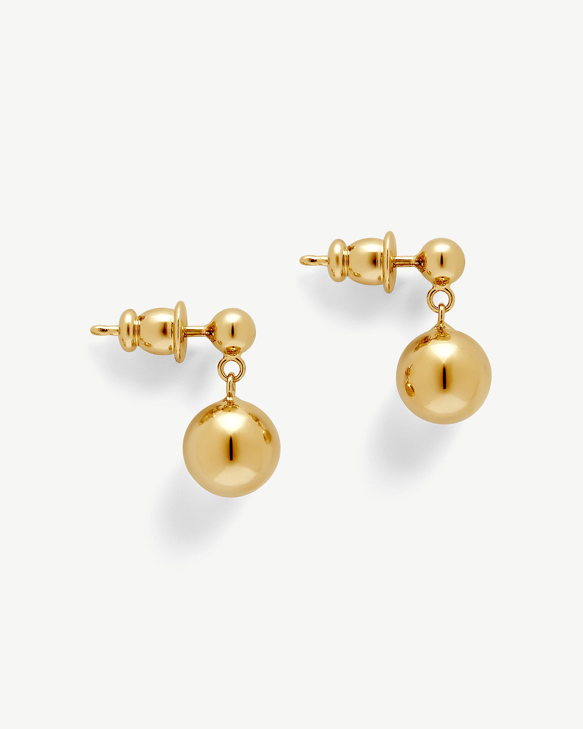 Pair of 22‑carat gold‑gilded drop earrings with polished spherical pendants