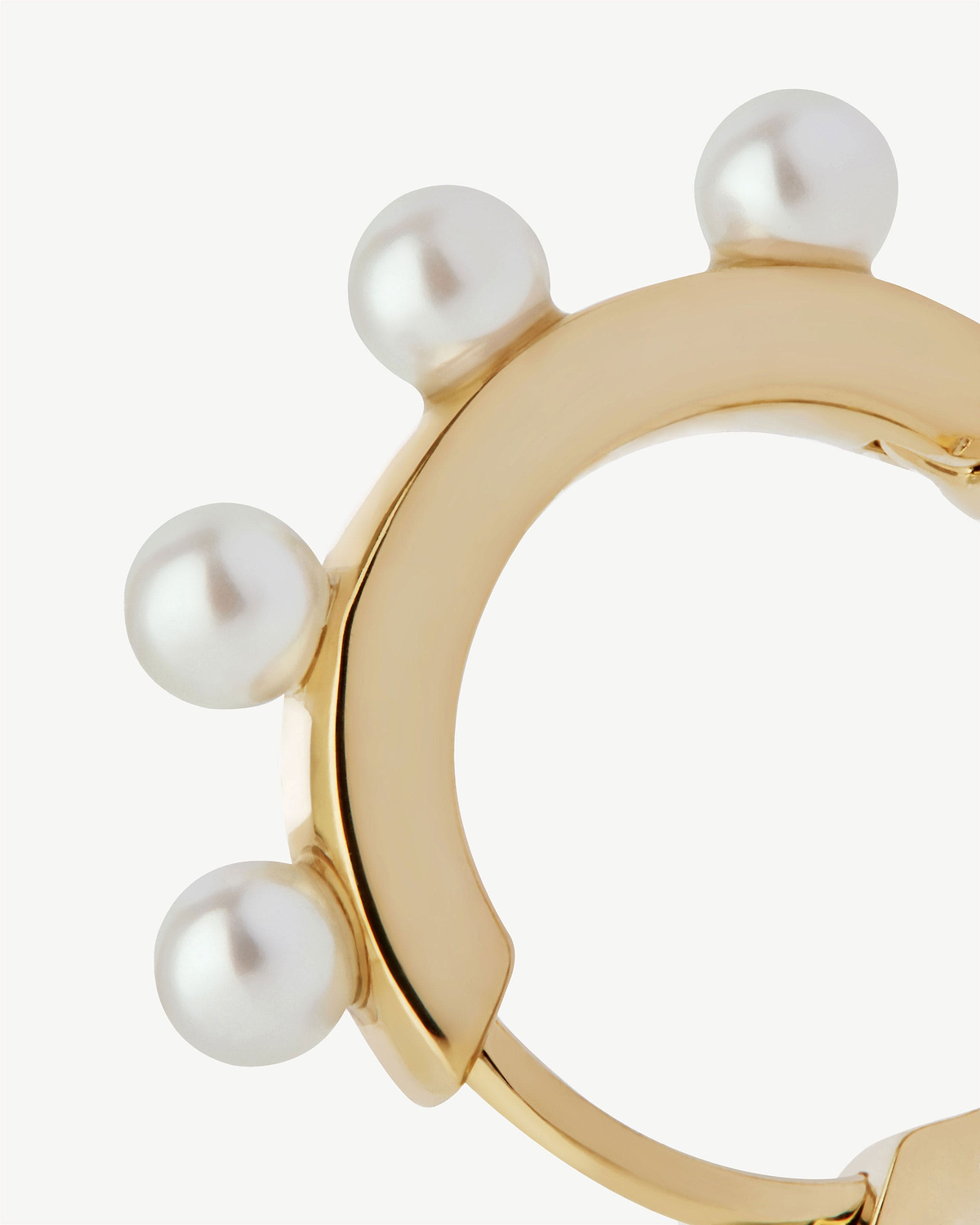 22 carat gold gilded pearl huggie with multiple round pearls along outer edge.