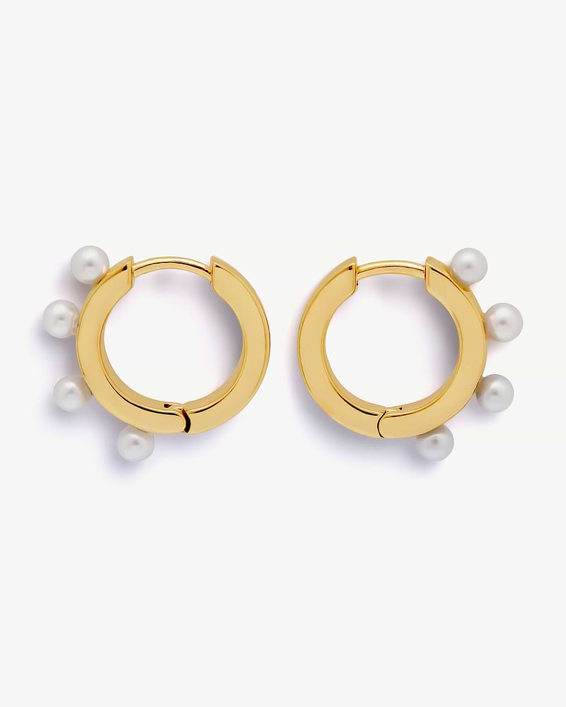 Pair of 22 carat gold-gilded huggie hoop earrings with white pearl embellishments.