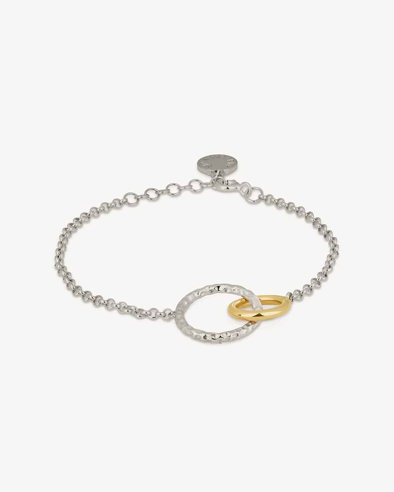 Sterling silver chain bracelet with a hammered silver ring and a gold-gilded ring.