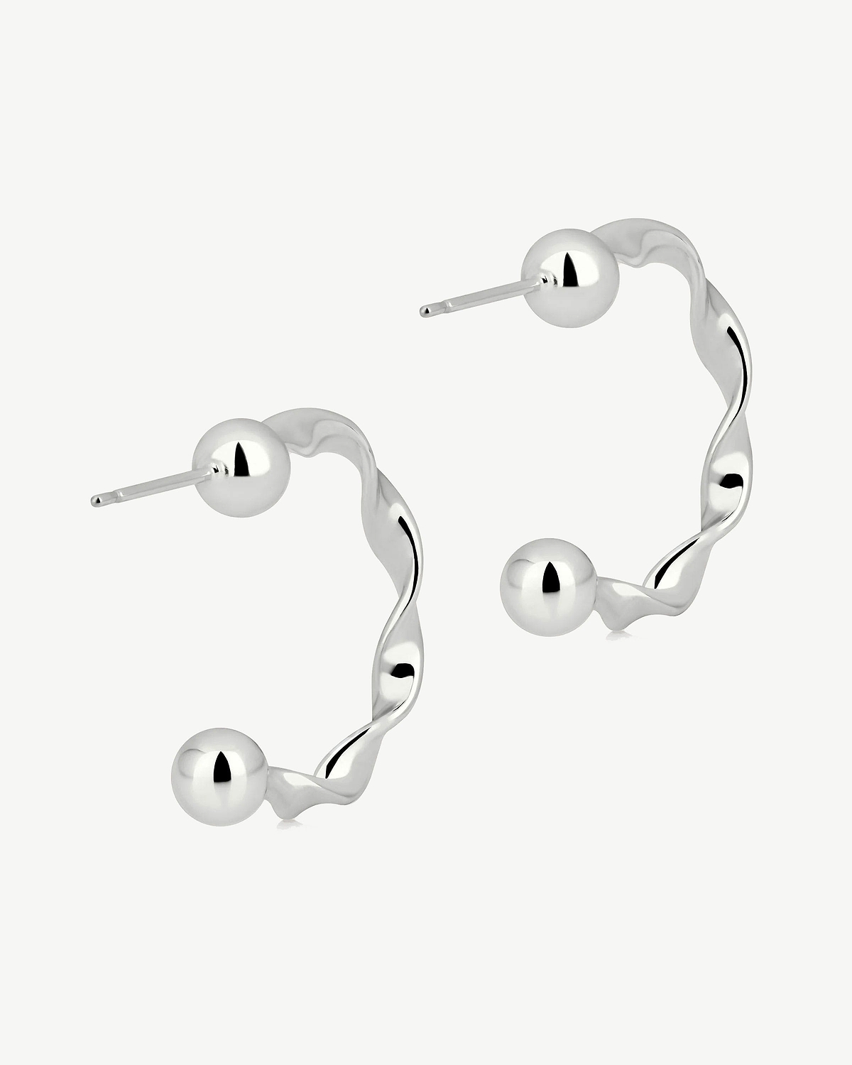 Pair of sterling silver crescent twisted hoop earrings with polished ball ends.