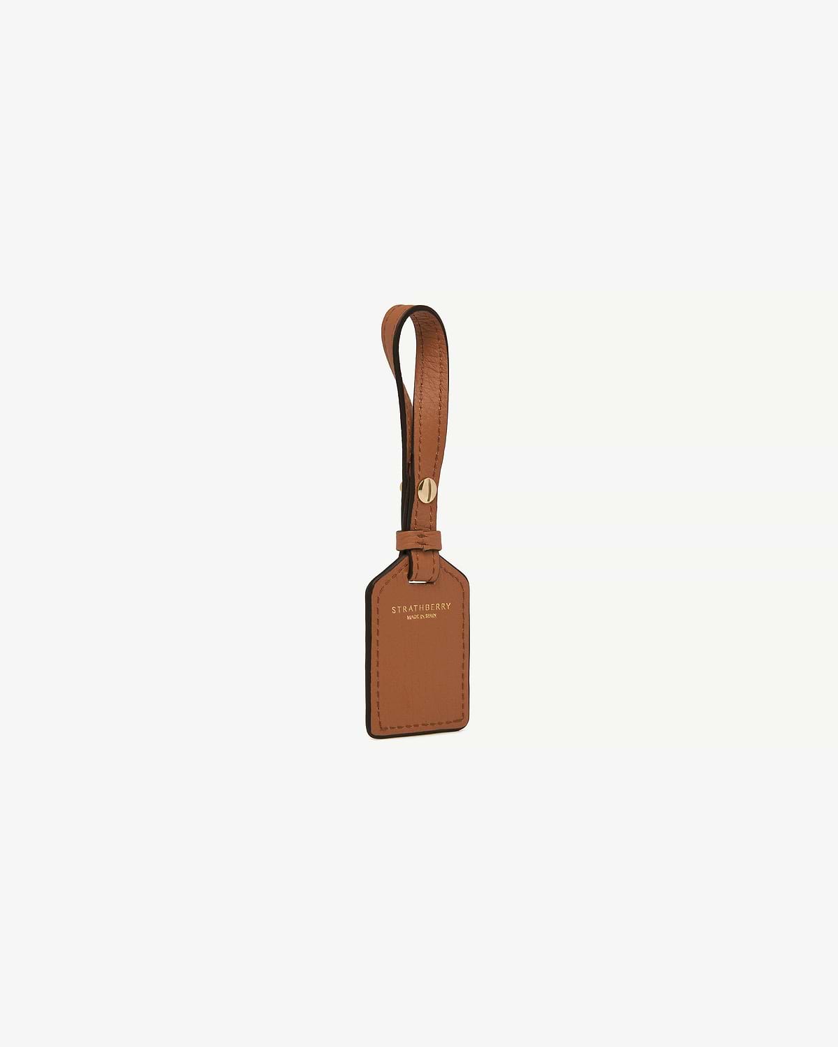 Tan leather luggage tag with strap and gold Strathberry logo
