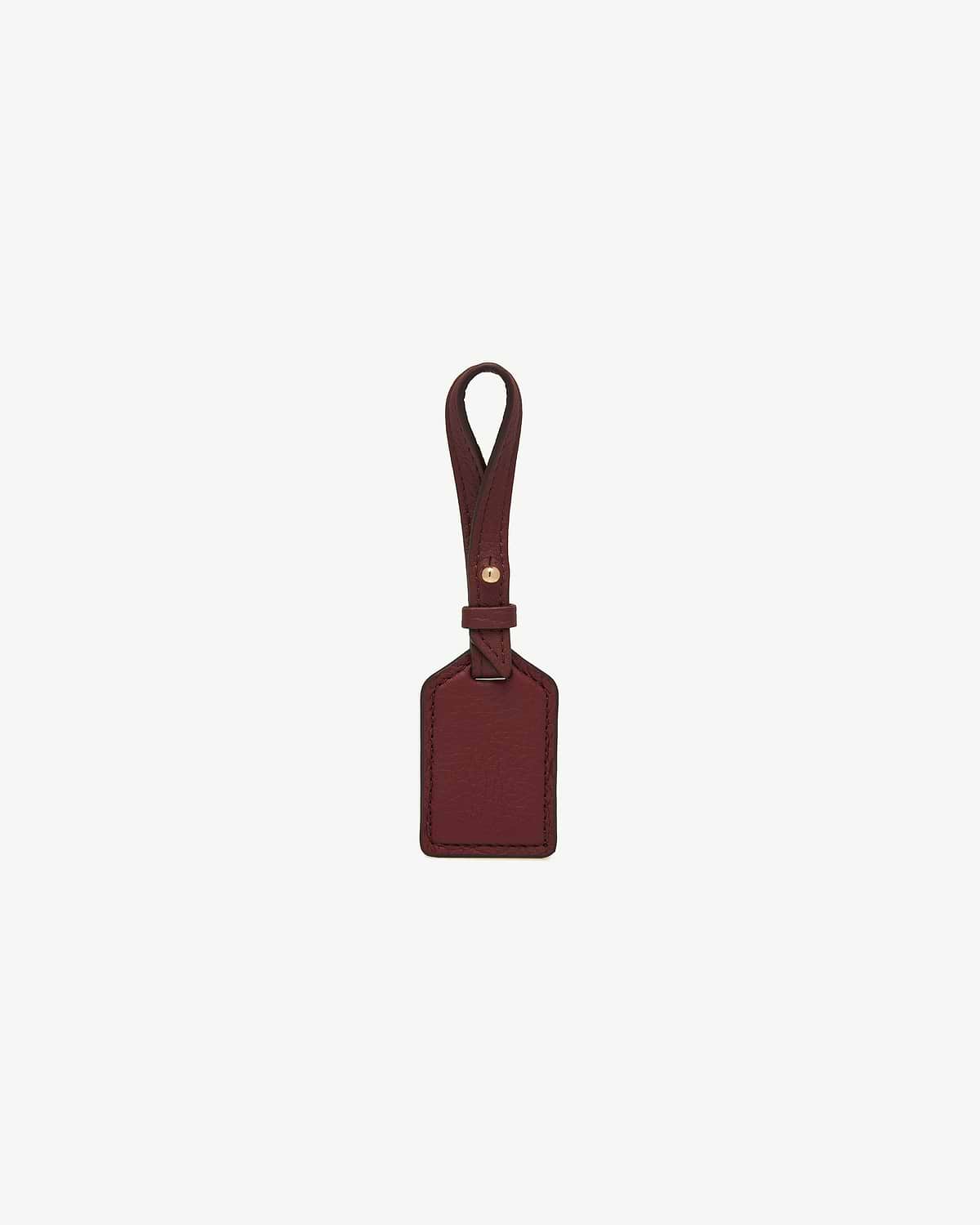 Oxblood leather tag with loop strap, rectangular panel, and gold-tone stud.