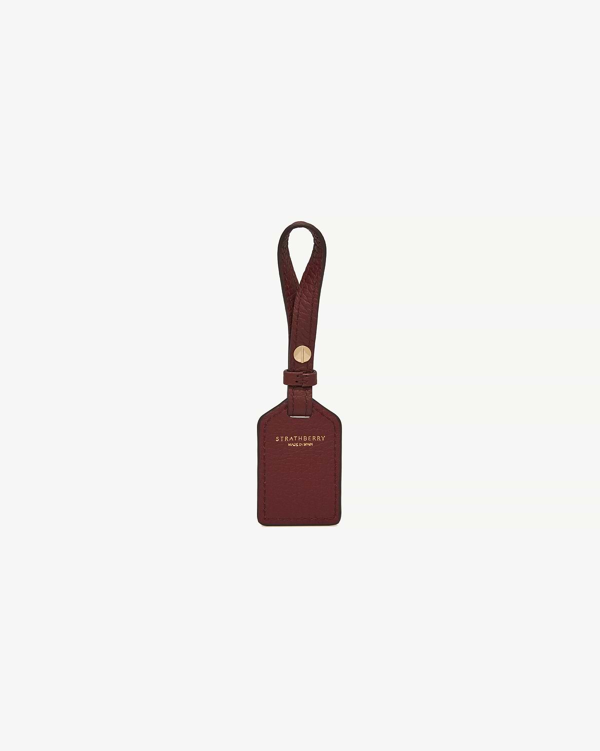 Oxblood leather luggage tag with strap and gold Strathberry logo.