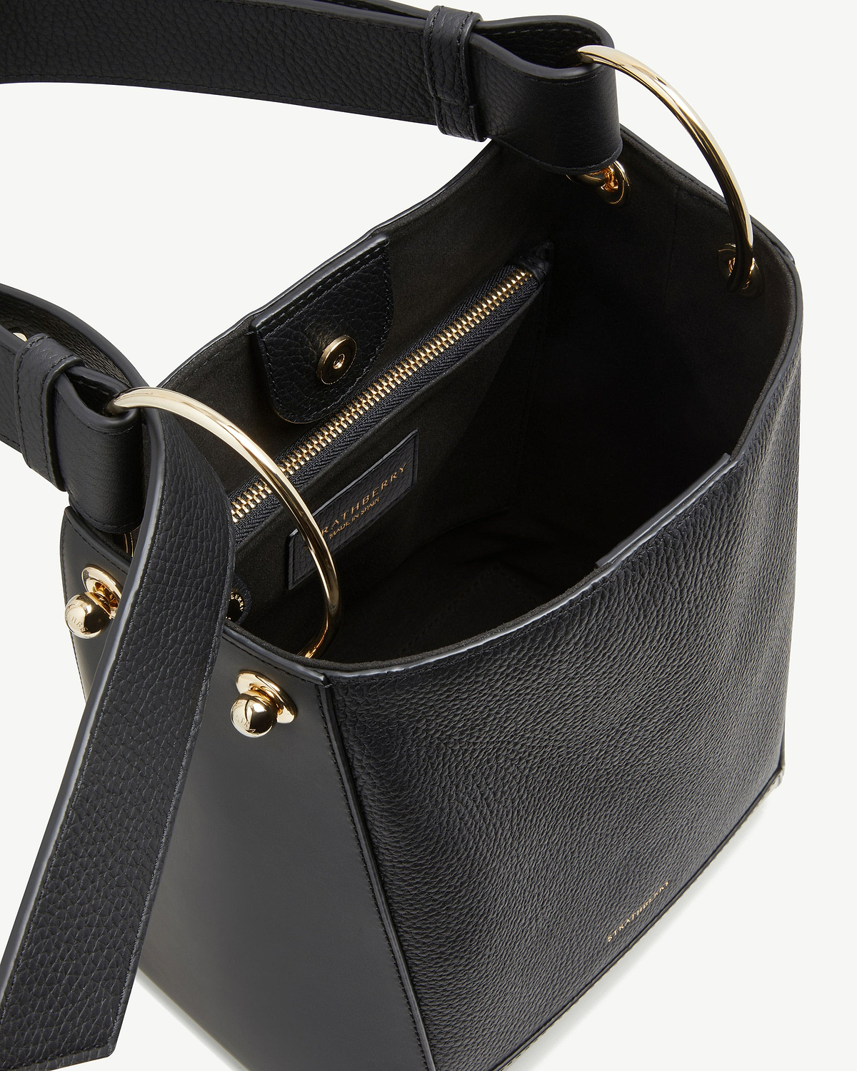 Black leather bucket bag with gold ring handles and internal zip pocket.
