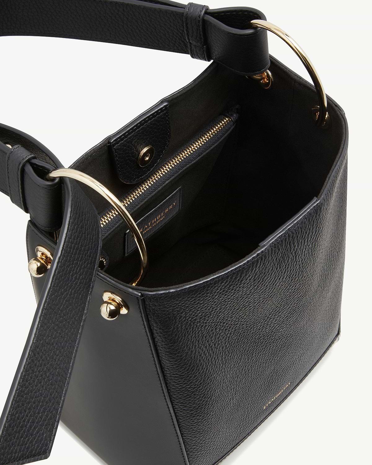 Black leather bucket bag with gold ring handles and internal zip pocket.