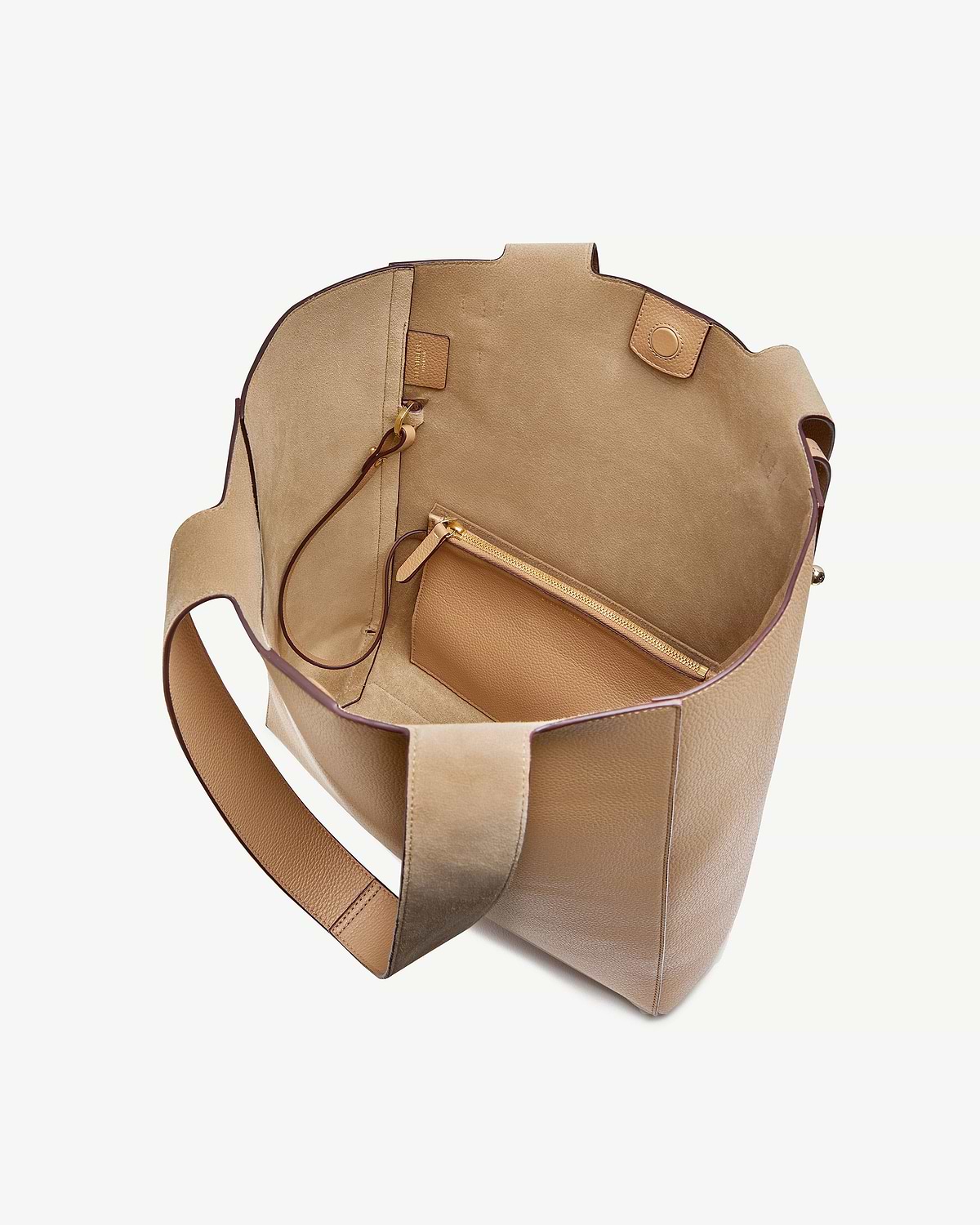 Open caramel leather tote bag showing suede interior and detachable zip pouch