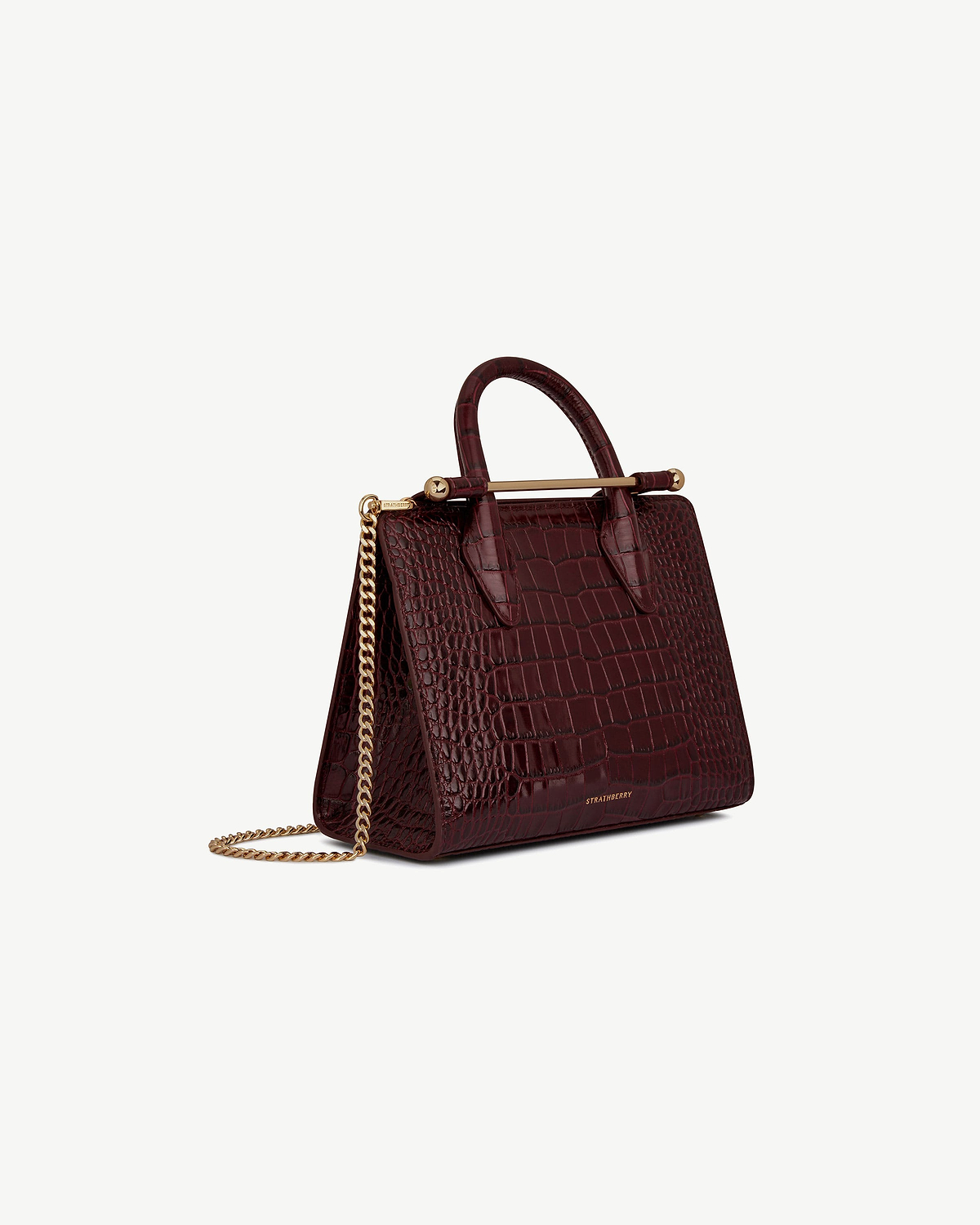Burgundy croc-embossed mini tote with gold chain strap, Strathberry logo visible.