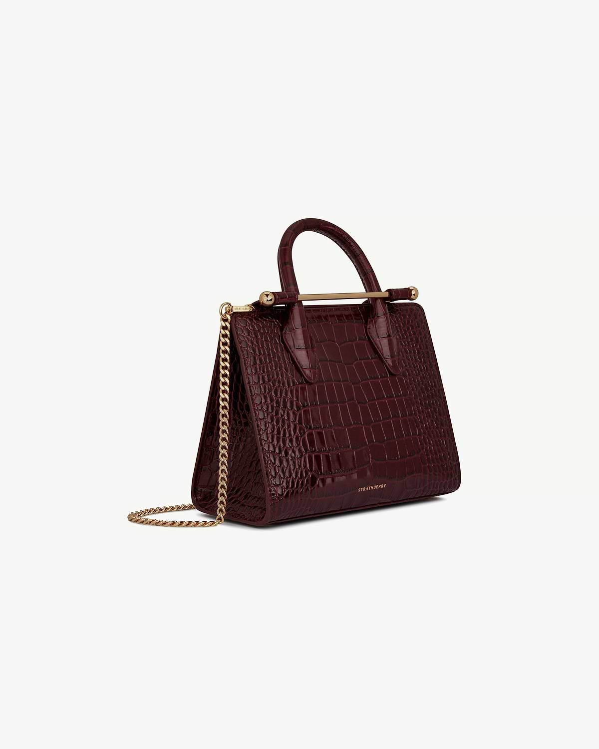 Burgundy croc-embossed mini tote with gold chain strap, Strathberry logo visible.