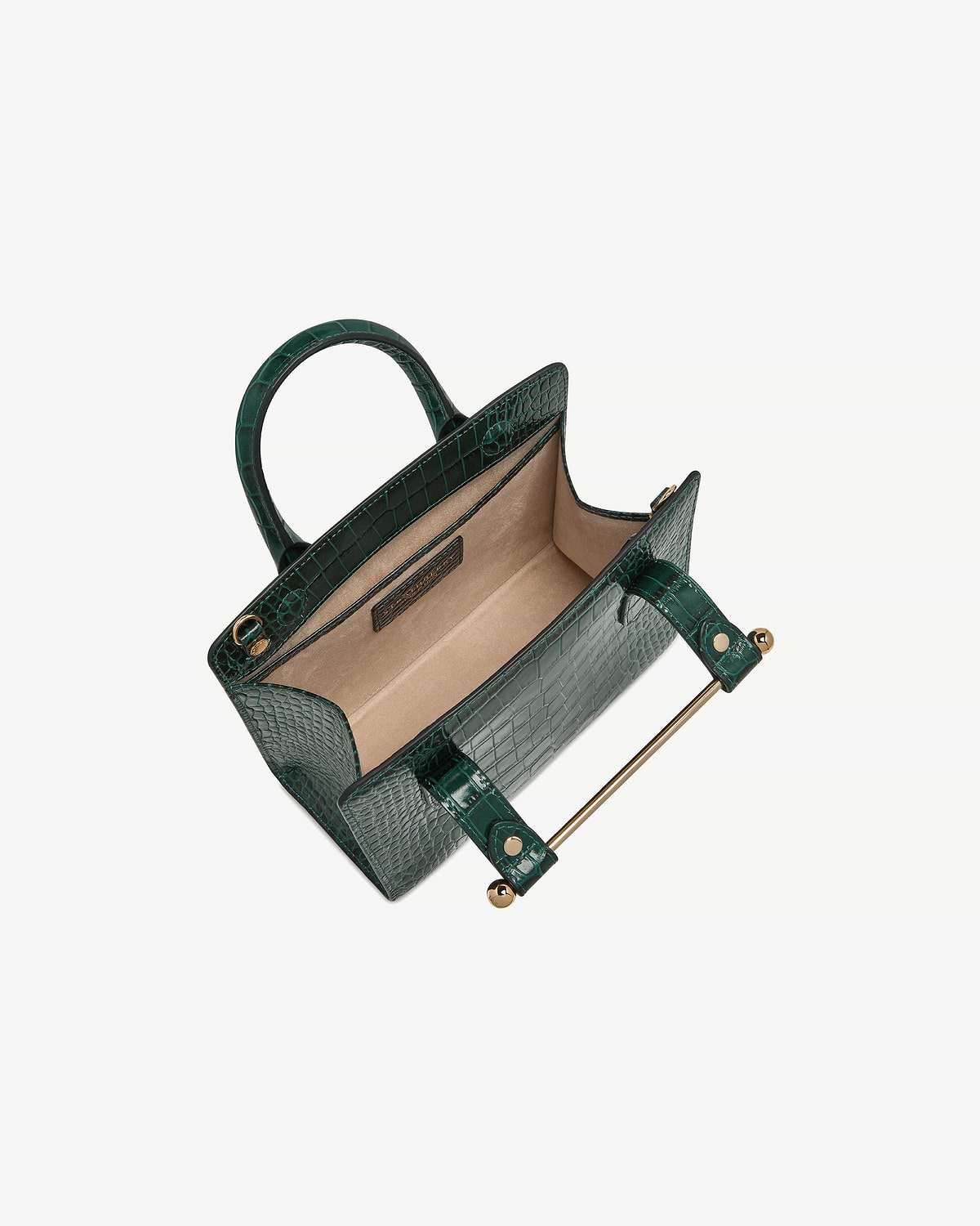 Green croc mini tote with open top, beige interior and gold metal bar.