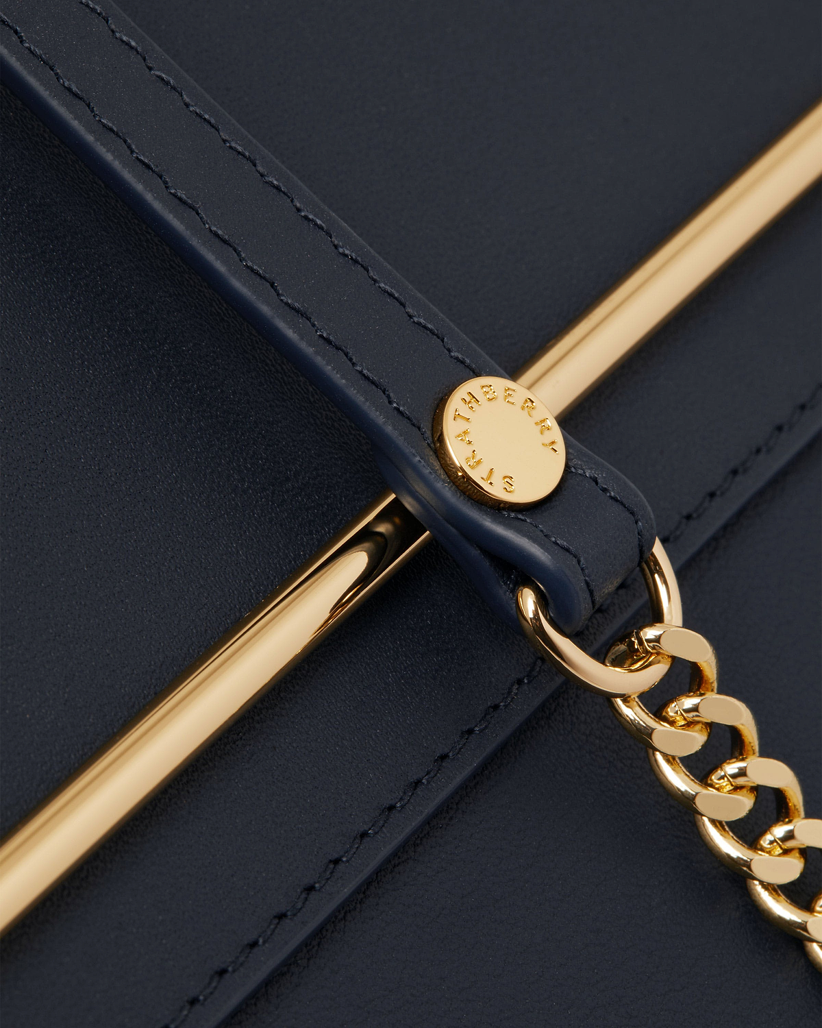 Marine blue leather strap with gold bar, chain and Strathberry engraved stud