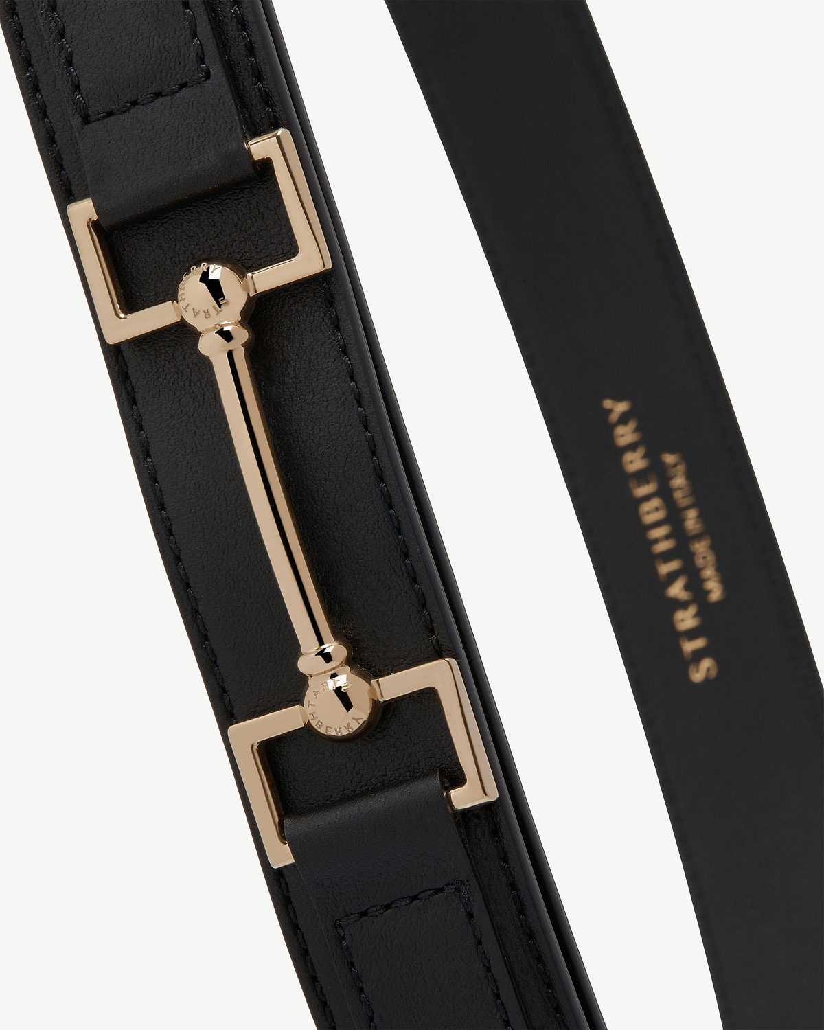 Black leather Stockbridge belt with gold bar hardware and Strathberry stamp.
