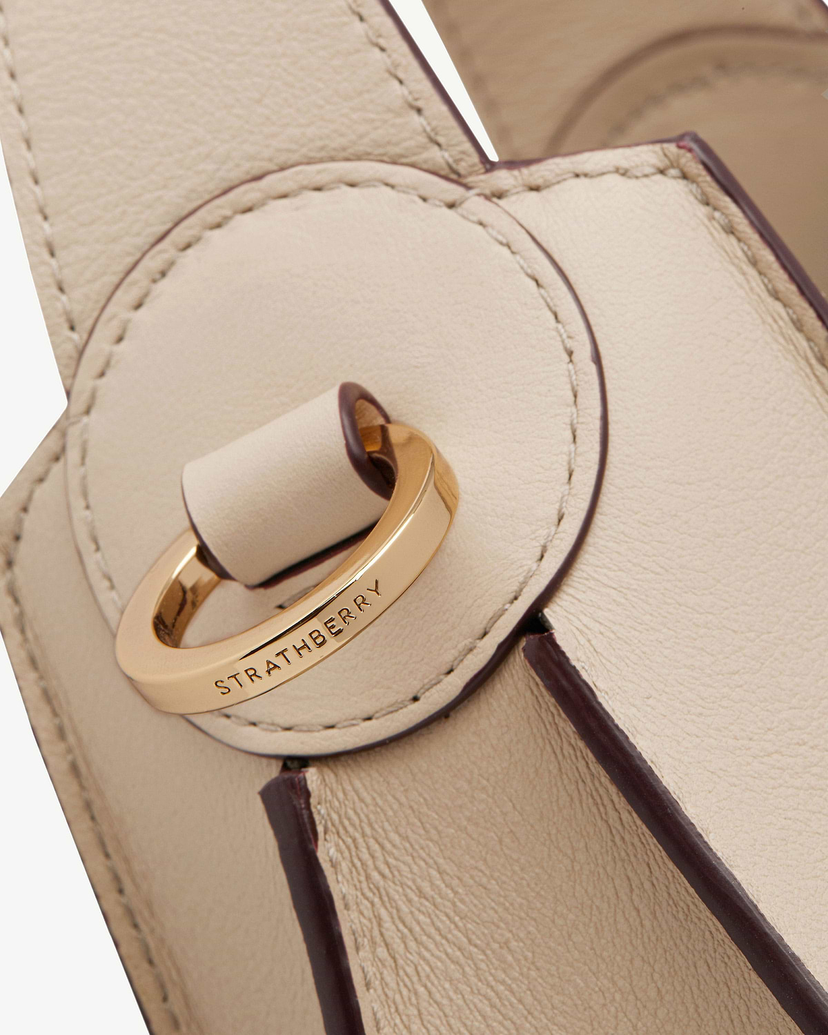Strathberry Arkshell oat leather bag with gold ring clasp and stitched edges