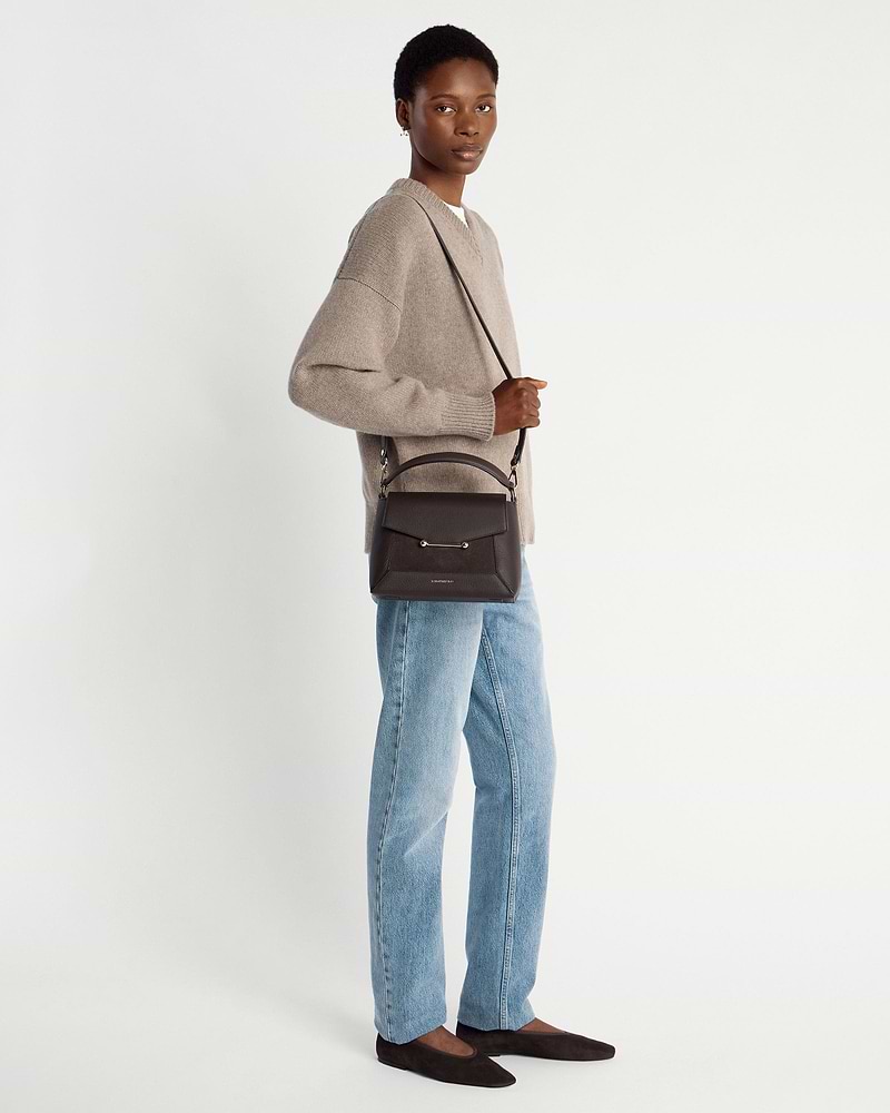 Woman wearing beige jumper and jeans carrying dark chocolate suede and leather mosaic bag.