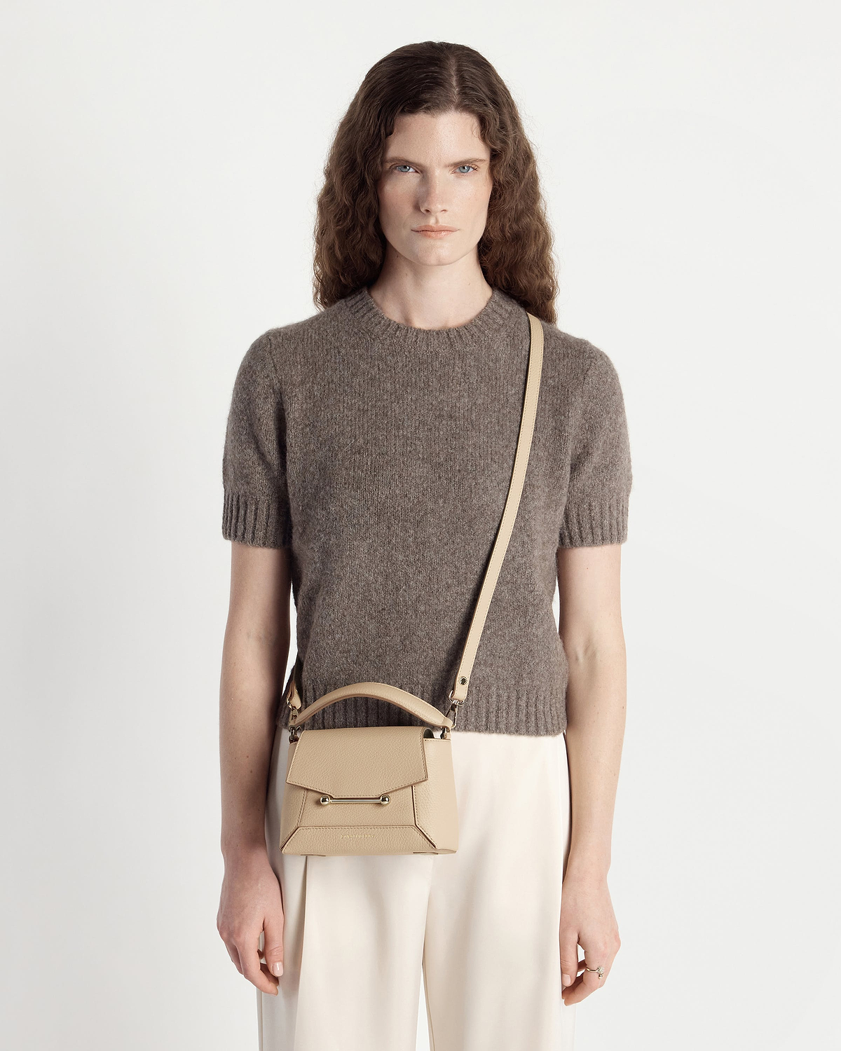 Model wearing sand Strathberry Mosaic Nano bag with long strap across body