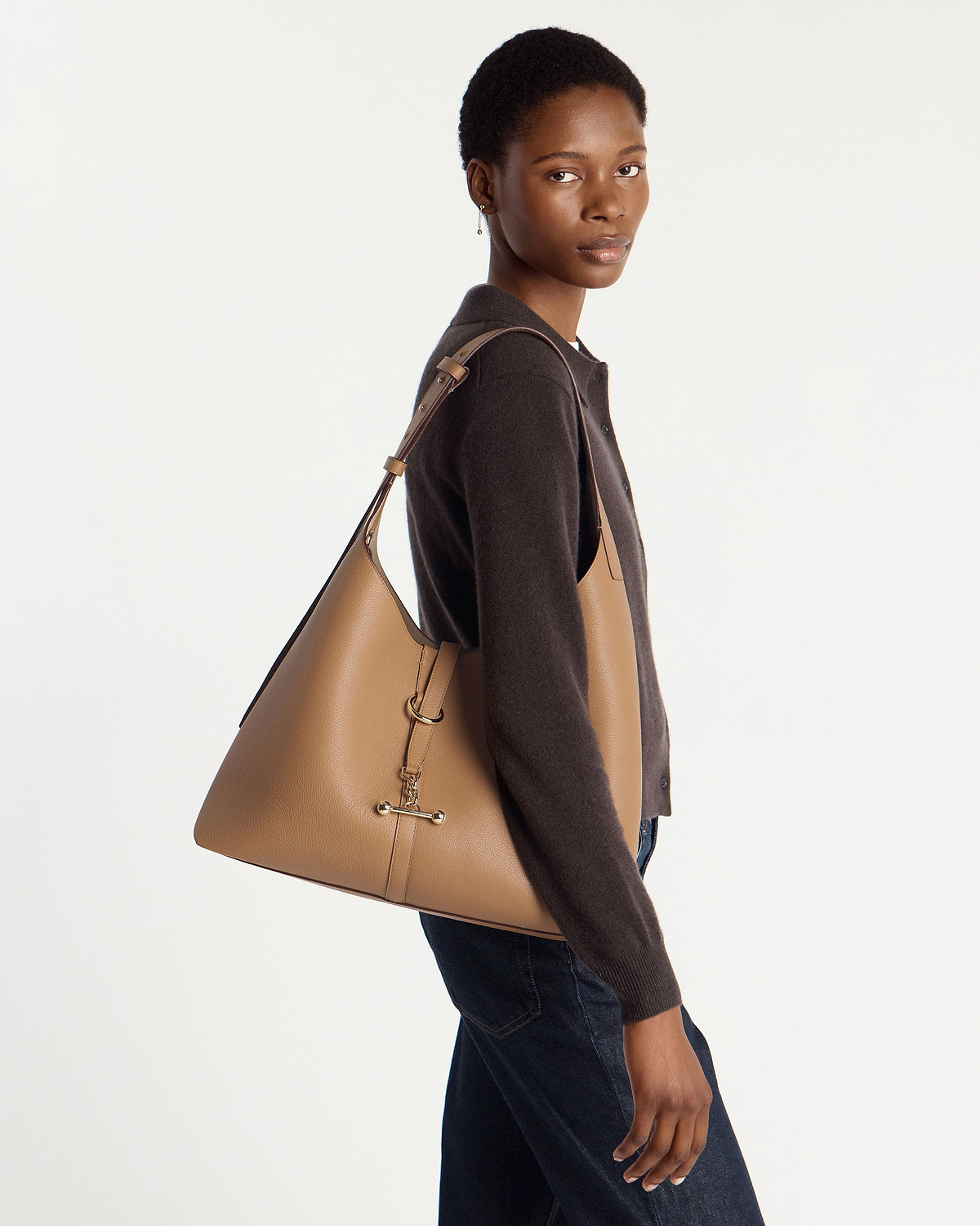 Model wearing caramel Kite Hobo Maxi bag on her shoulder, side profile.