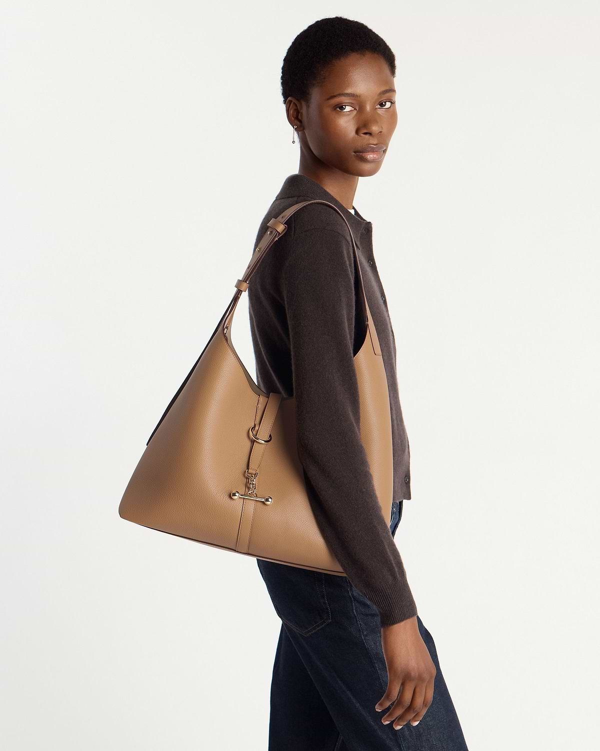 Model wearing caramel Kite Hobo Maxi bag on her shoulder, side profile.