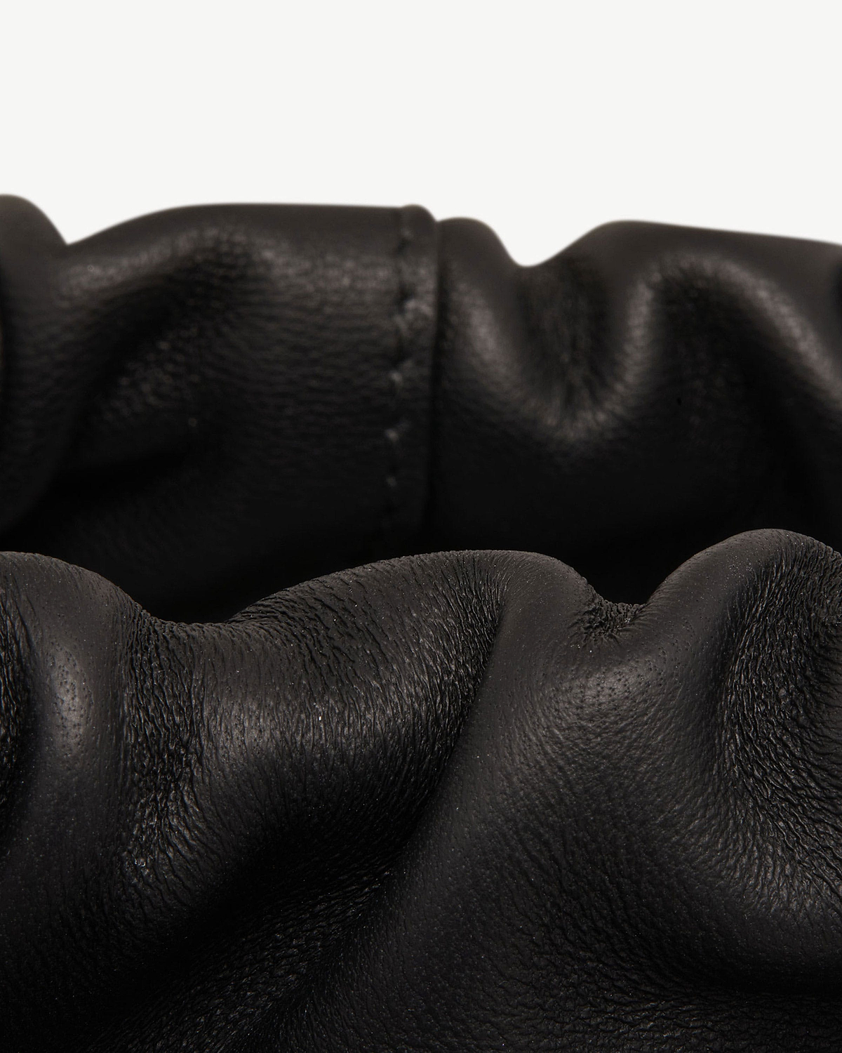 Black leather drawstring bag with gathered ruched top and visible grain texture.