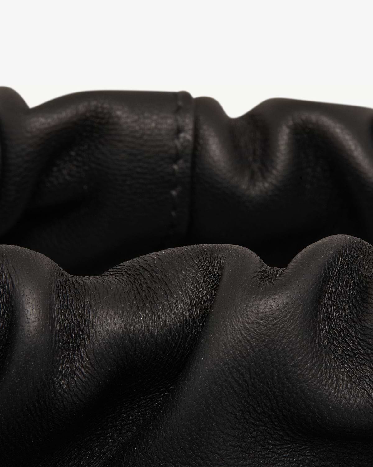 Black leather drawstring bag with gathered ruched top and visible grain texture.