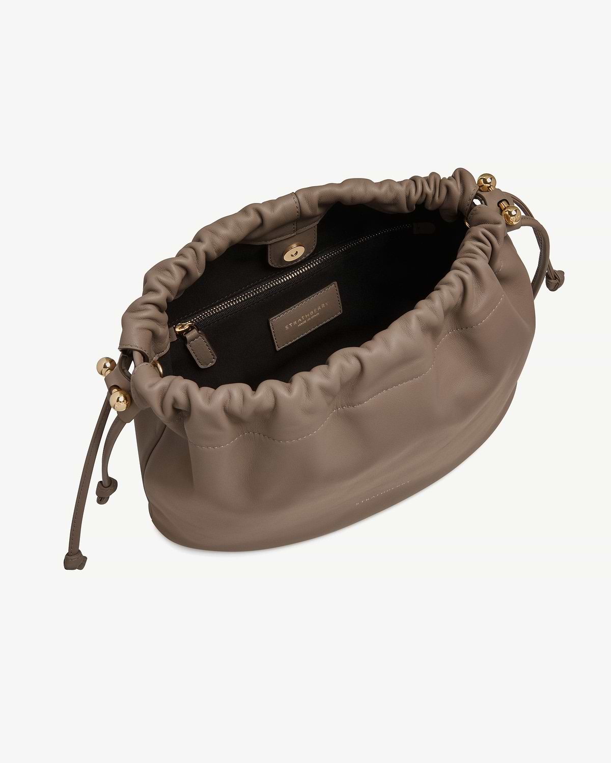 Taupe Strathberry Charlotte Midi drawstring bag open showing interior, zip pocket and gold hardware.