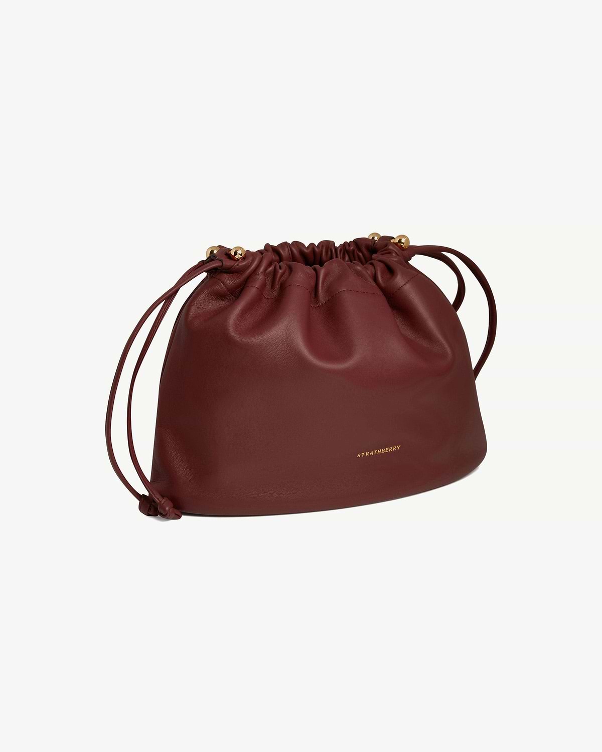 Oxblood leather Charlotte Midi drawstring bag with gathered top and gold Strathberry logo.