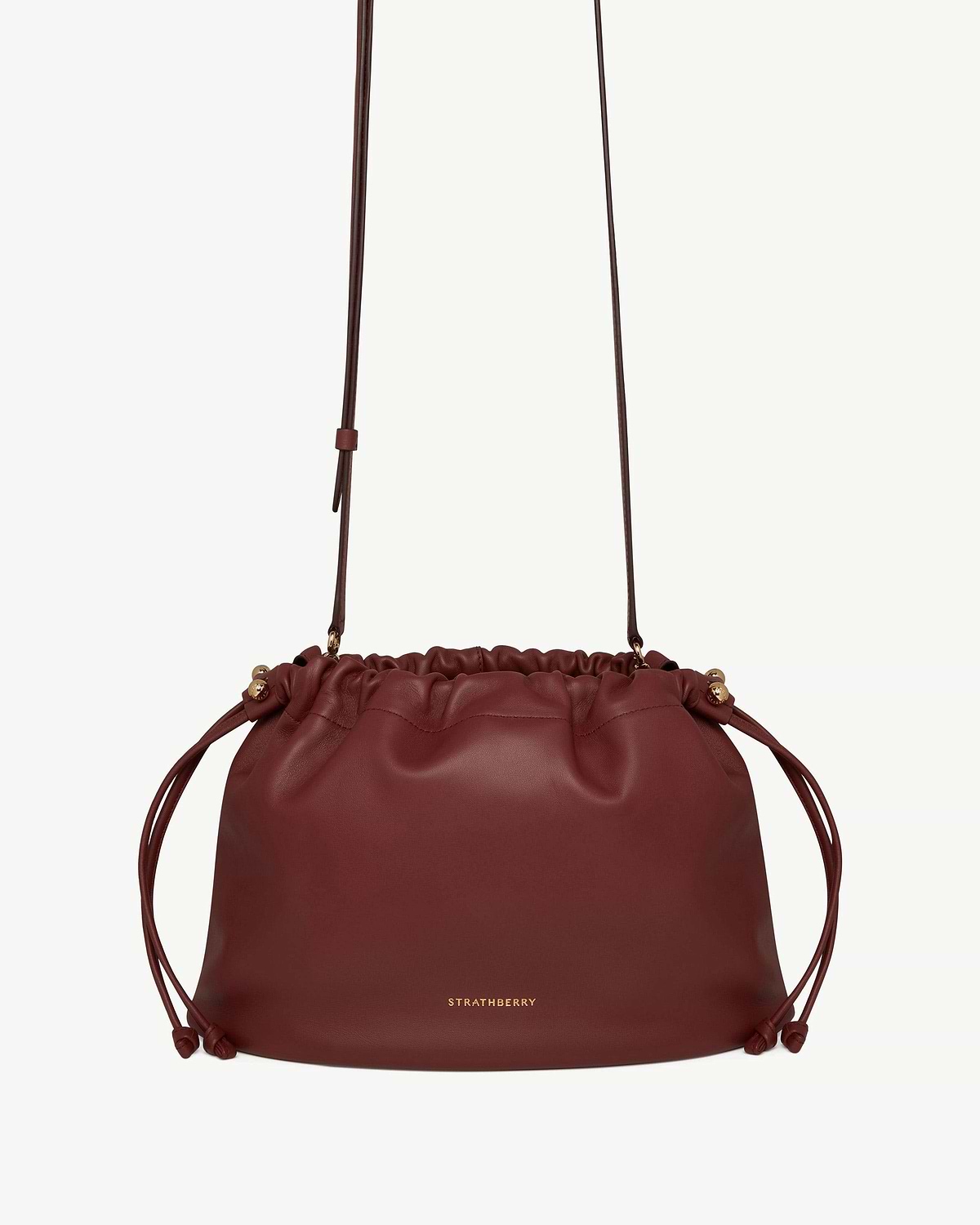 Oxblood leather drawstring bag with adjustable shoulder strap, Strathberry logo centre front