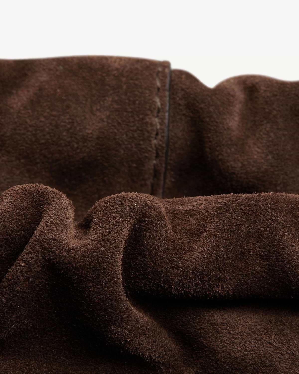 Close-up of chocolate suede showing stitching and gathered opening detail.