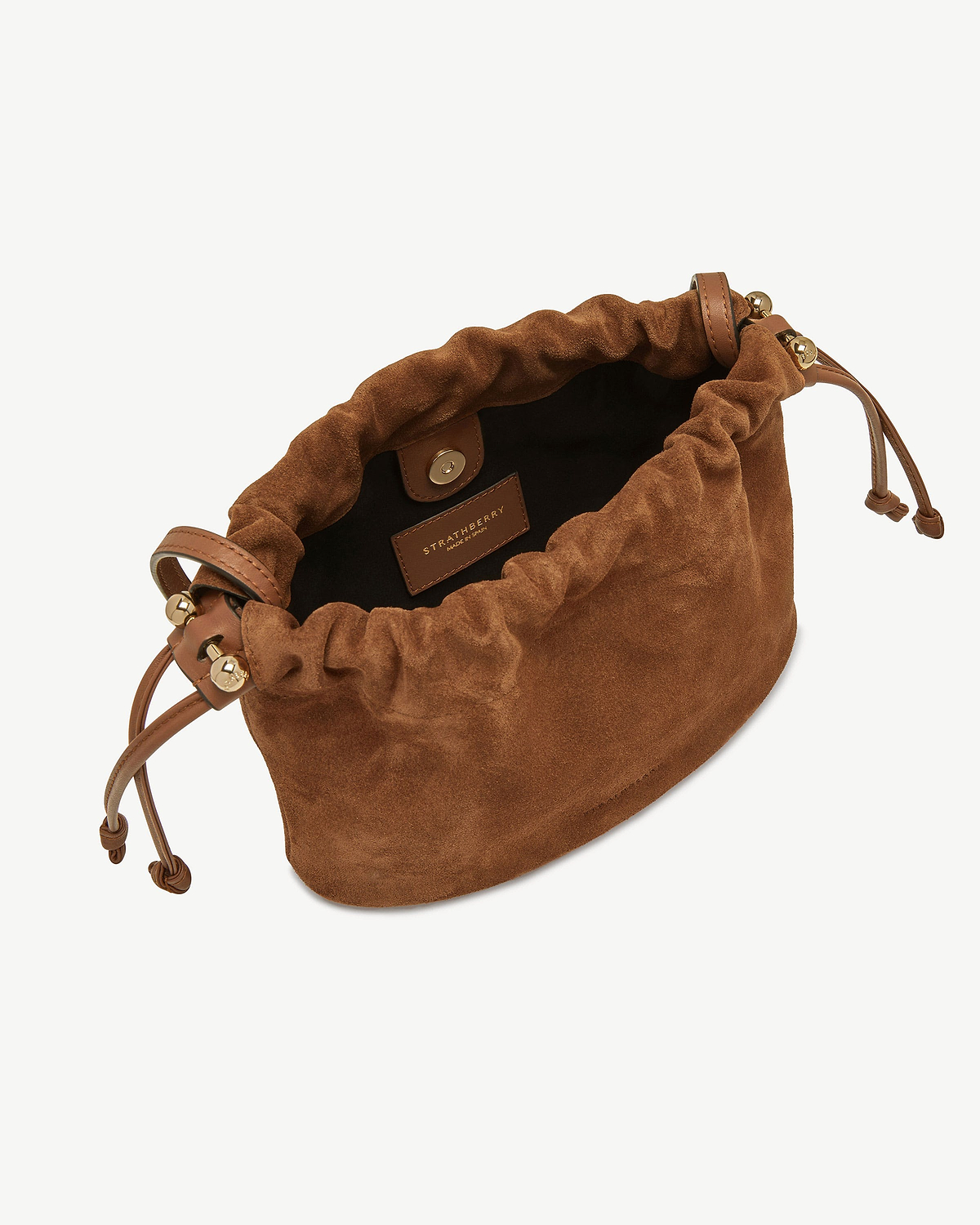 Strathberry tan suede drawstring bag with gold hardware and leather cords.