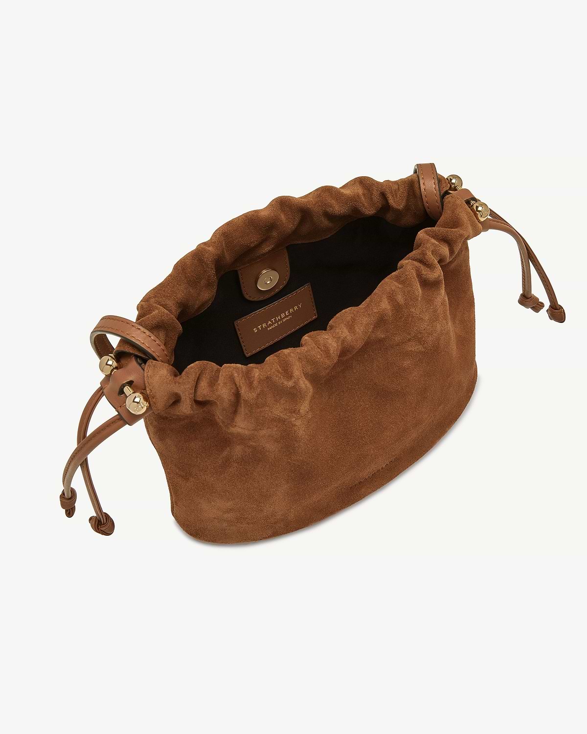 Strathberry tan suede drawstring bag with gold hardware and leather cords.